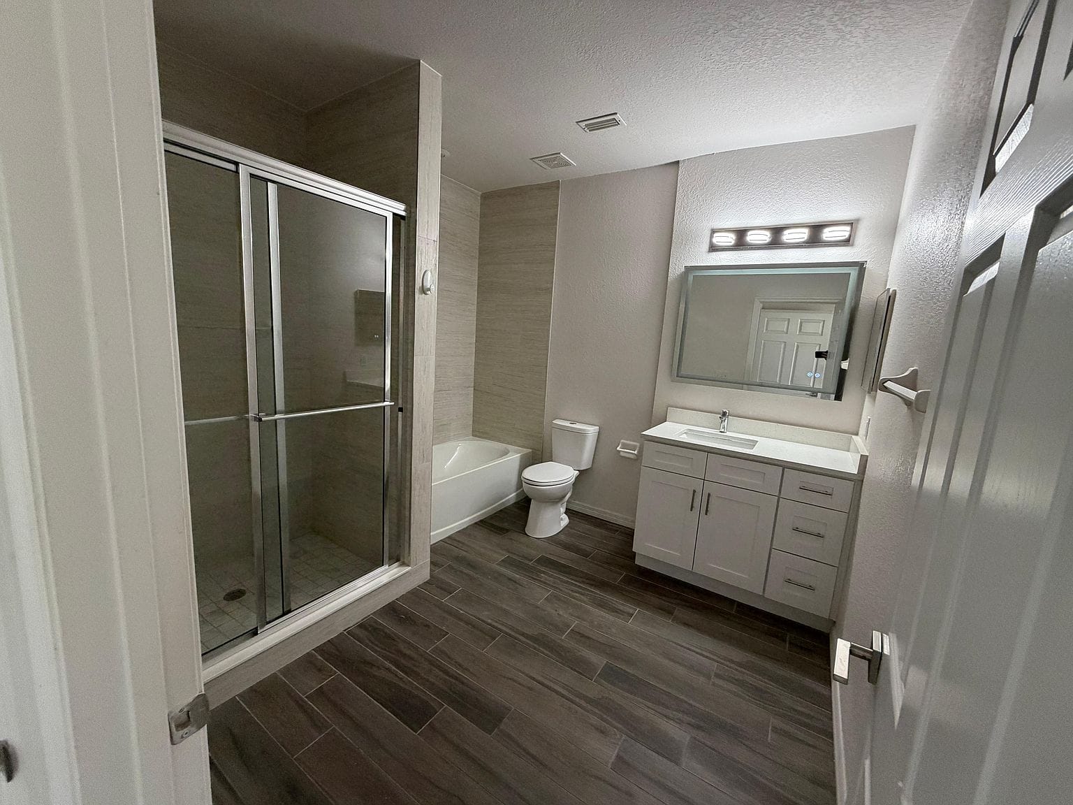 Baño con ducha de vidrio y lavabo con gabinete
